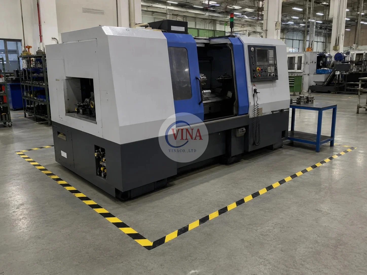 Ảnh minh hoạ băng keo cảnh báo sọc vàng đen dán viền quanh khu vực máy CNC trong nhà xưởng công nghiệp