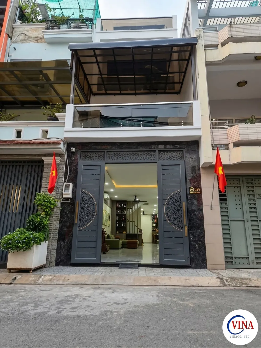 Toàn cảnh mặt tiền nhà phố có lắp mái che canopy sân thượng và lan can kính