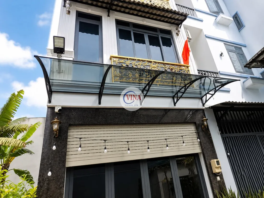 Toàn cảnh mặt tiền nhà phố với mái che lấy sáng canopy khung đen lắp trên ban công