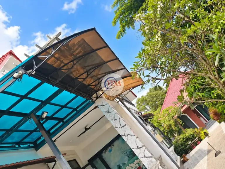 Ở góc nhà, mái canopy nằm sát mái lấy sáng tấm xanh dương; trong bóng râm tấm nhìn sẫm hơn.