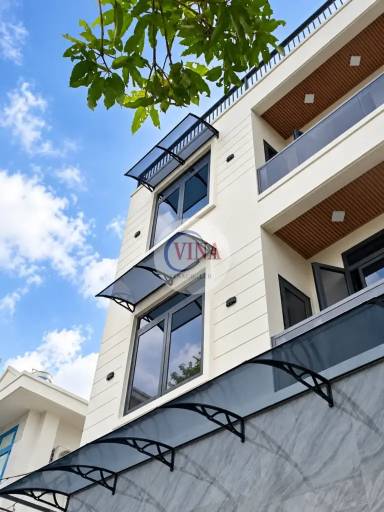 Hai mái cửa sổ dùng cùng kiểu tay đỡ vòm đen với mái trên cổng.