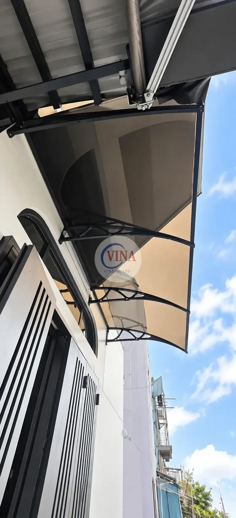 Nhìn dọc mép mái: ba tay đỡ vòm đen nối với thanh viền chạy suốt chiều dài tấm.