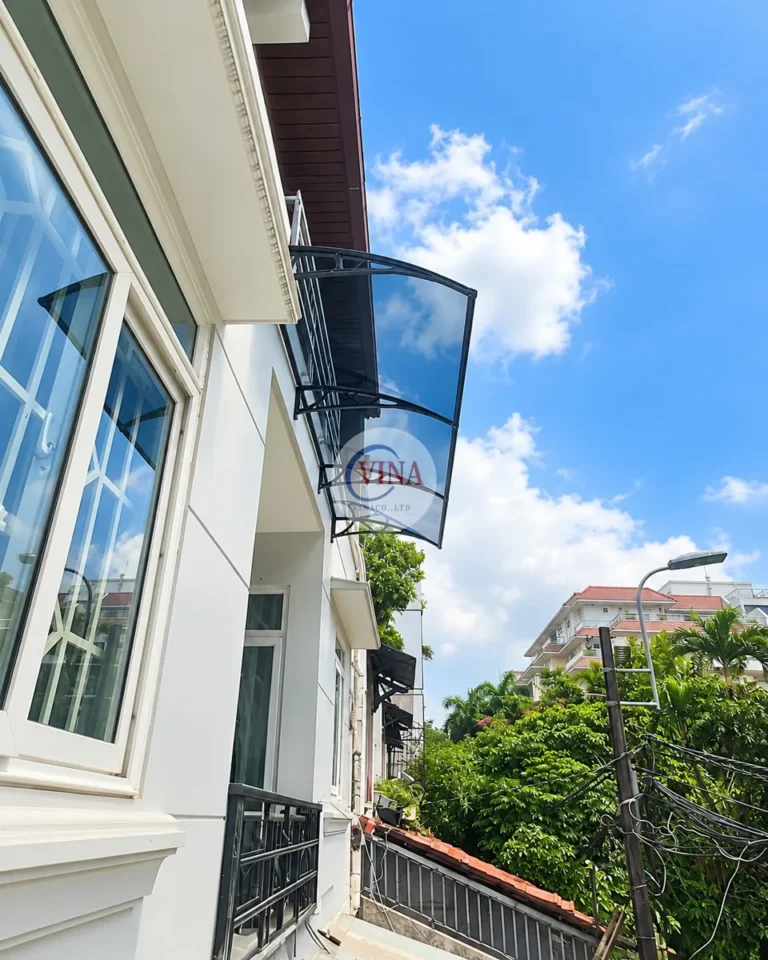 Góc nhìn nghiêng: tấm polycarbonate uốn cong theo tay đỡ màu đen, vẫn nhìn thấy bầu trời qua tấm mái.